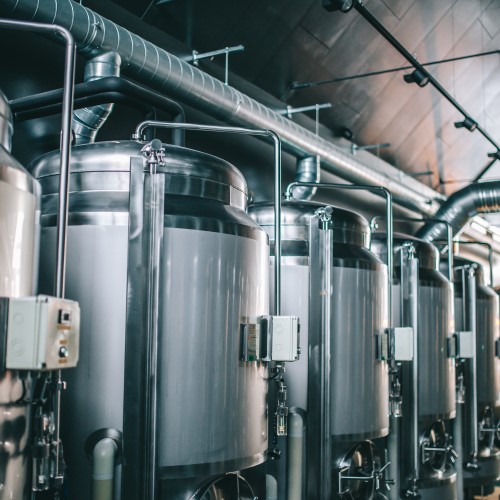 Line of metal fermenters in a brewery